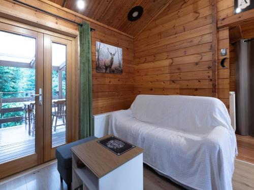ein Schlafzimmer mit einem Bett in einem Holzzimmer in der Unterkunft lOrée in Biron