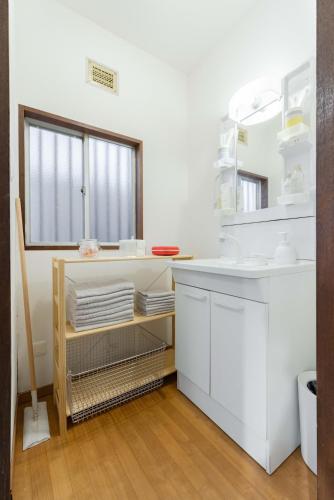 a white bathroom with a sink and a mirror at Tsuga1976 in Chiba