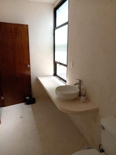 a bathroom with a sink and a window at Casa Nahox in Hunucmá