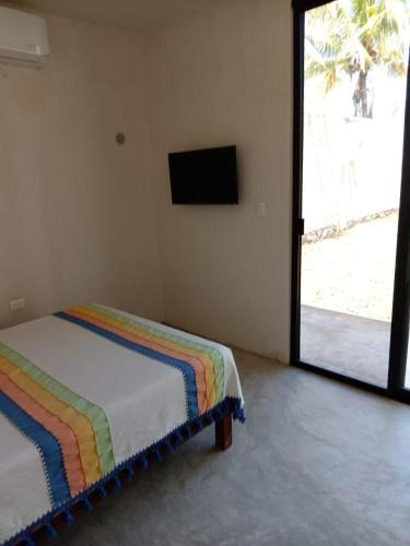 a bedroom with a bed with a colorful blanket at Casa Nahox in Hunucmá