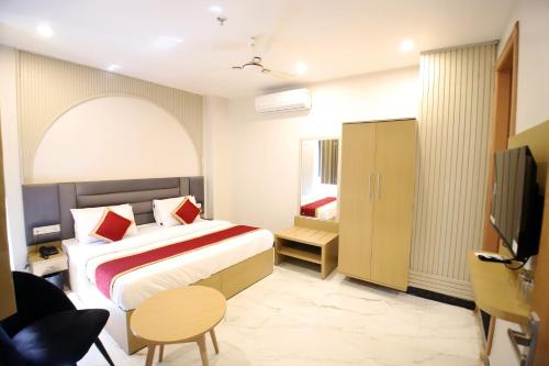 a hotel room with a bed and a television at Hotel Ember in Alwar