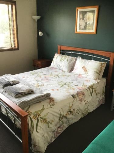 a bedroom with a large bed with a blanket at Villa on Ferguson in Ipswich