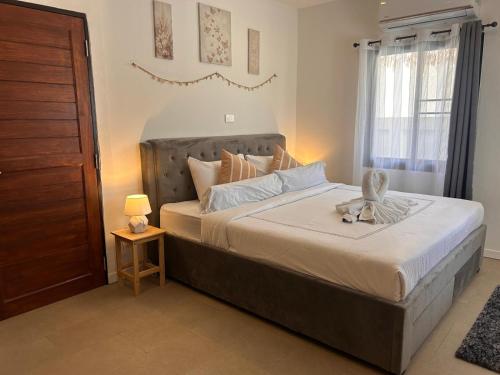 a bedroom with a large bed with a dresser and a table at Villa L Aurora in Taling Ngam Beach