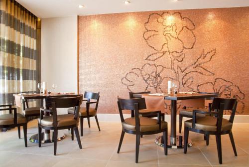 a restaurant with tables and chairs and a wall at Hilton Mainz in Mainz
