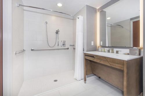 a white bathroom with a shower and a sink at DoubleTree by Hilton Raleigh-Cary in Cary