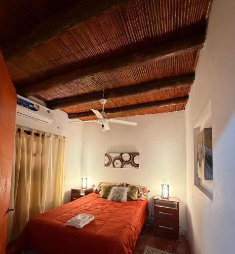 a bedroom with a red bed and a ceiling at Mis Montañas in Tinogasta