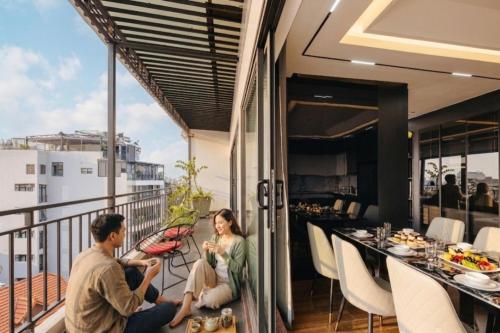 a man and a woman sitting on a balcony at Santori studio Hanoi in Hanoi