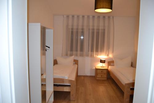 a small room with two beds and a window at Aparthotel Sebastian in Erding