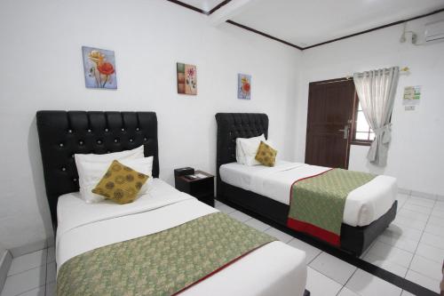 a hotel room with two beds and a window at Yasminstar Hotel in Muntok