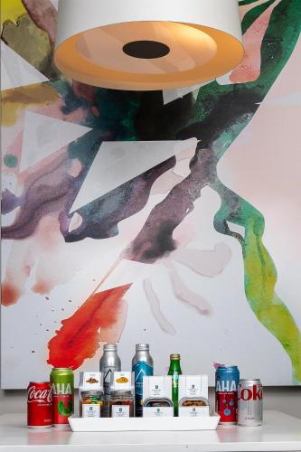 a pendant light and soda cans in front of a painting at Embassy Suites by Hilton San Diego Bay Downtown in San Diego