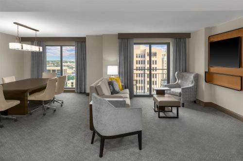 a living room with a table and chairs and a television at Embassy Suites San Antonio Riverwalk-Downtown in San Antonio