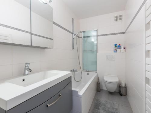 a white bathroom with a sink and a toilet at Romanza - 0405 + park.38 in Middelkerke