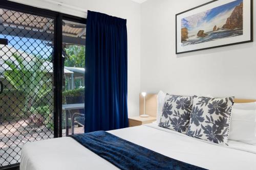 a bedroom with a bed and a large window at Sunset Escape in Broome