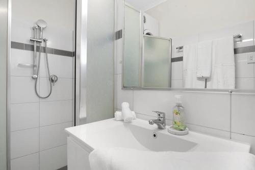 a white bathroom with a sink and a shower at Sunset Escape in Broome
