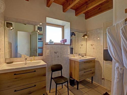 a bathroom with two sinks and a chair in it at Gîte rustique 6 pers avec cheminée et grand jardin, animaux acceptés - FR-1-496-61 in Les Salles