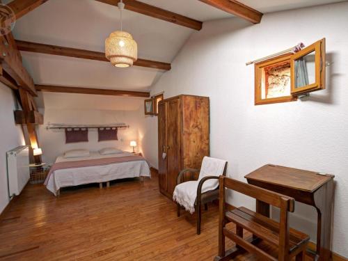 a bedroom with a bed and a table and a chair at Gîte rustique 6 pers avec cheminée et grand jardin, animaux acceptés - FR-1-496-61 in Les Salles