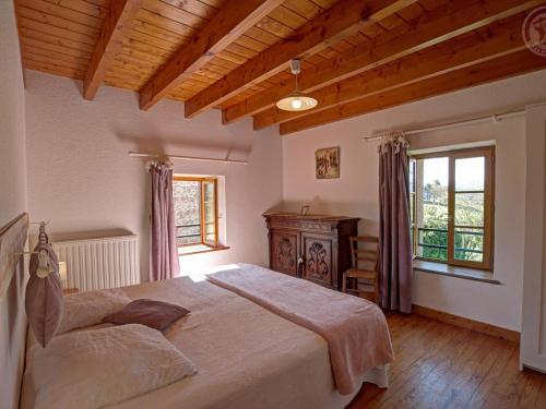 a bedroom with a large bed and a wooden ceiling at Gîte 4 pers avec jardin privé et animaux admis - FR-1-496-66 in Les Salles