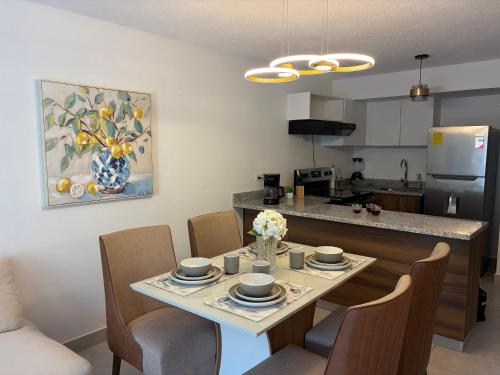 a kitchen and dining room with a table and chairs at Modern top floor apartment with pool in San Marcos