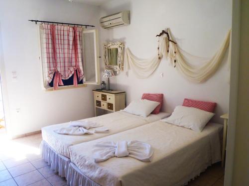 two beds sitting next to each other in a bedroom at Plori Studios and Apartments in Aegiali