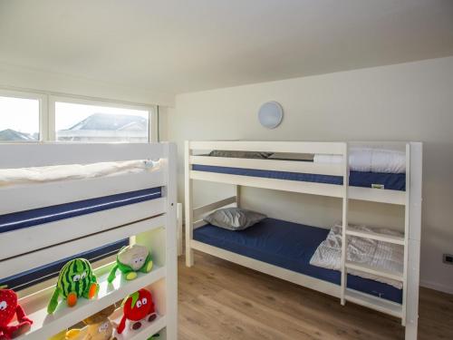 two bunk beds in a room with wooden floors at Villa Tamarisk - + box in Middelkerke