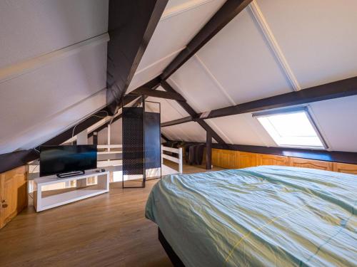 a bedroom with a bed and a tv in it at Westenwind - Nr. 3 + park. in Middelkerke