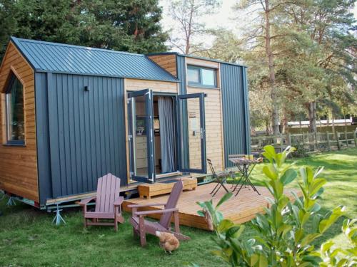 a tiny house with two chairs and a table at Sugar Hut by Tiny Away in Great Horkesley