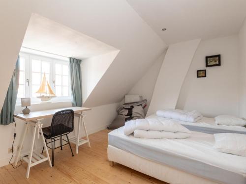 two beds in a room with a desk and a table at Notre Dame in Nieuwpoort