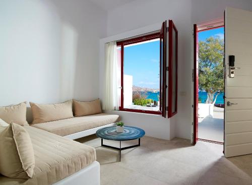 a living room with a couch and a table at Unique Milos Suites in Pollonia