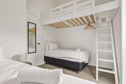 a bedroom with a bunk bed and a ladder at Roam Taupo Lakefront Combined Units 1&2 in Taupo