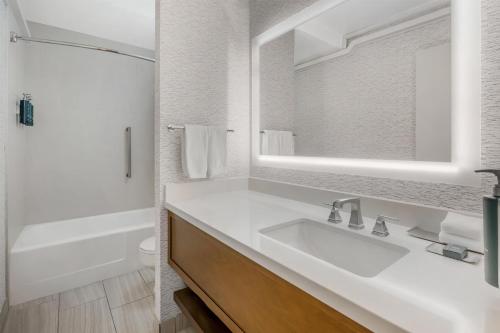 a white bathroom with a sink and a mirror at DoubleTree by Hilton Spokane City Center in Spokane