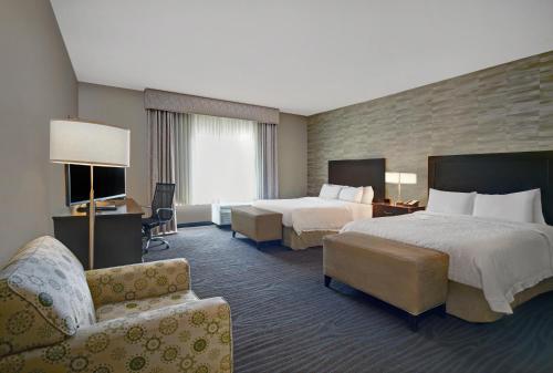 a hotel room with two beds and a couch at Hampton Inn and Suites Robbinsville in Robbinsville