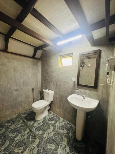 a bathroom with a toilet and a sink at Rainforest Tea Garden Cabin-River View in Deniyaya
