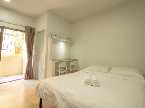 a bedroom with a bed with white shoes on it at Prukpibul Apartment in Bangkok