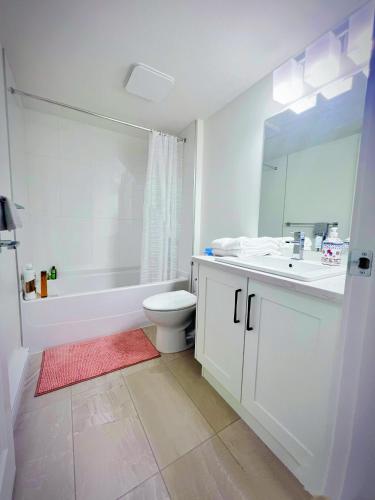 a white bathroom with a tub and a toilet and a sink at Kris Anclam in Langley