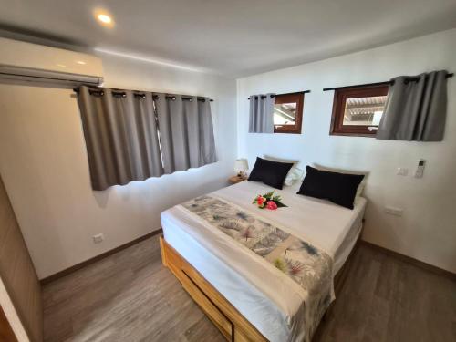 a bedroom with a bed with flowers on it at Le Rainoa - Beach House in Taputapuapea