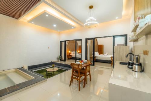 a kitchen and living room with a table and a bed at Ghania Villas Melasti in Ungasan