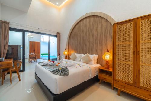a bedroom with a large bed and a table and a desk at Ghania Villas Melasti in Ungasan