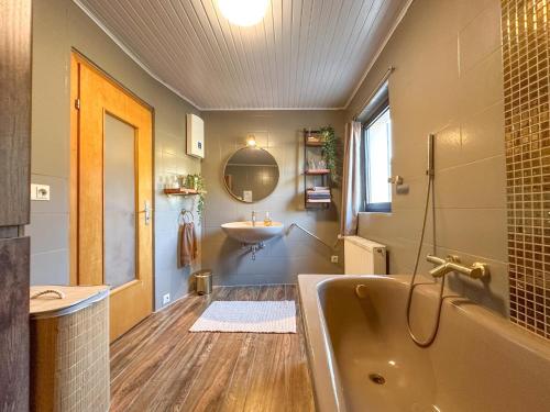 a bathroom with a tub and a sink at Burgen in Burgen