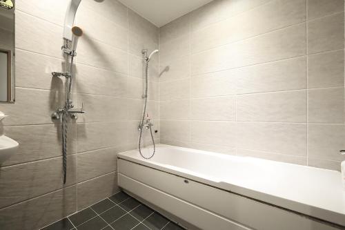 a bathroom with a shower and a bath tub at Ingye Joy Hotel in Suwon