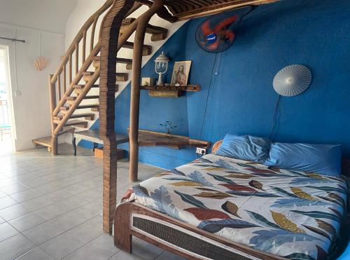a bedroom with a bed and a blue wall at Kreolia Blue-Waters in Trou d'Eau Douce