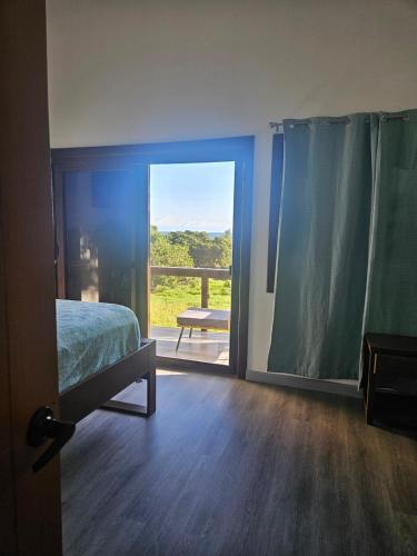 a bedroom with a bed and a sliding glass door at Sea view house in Utila