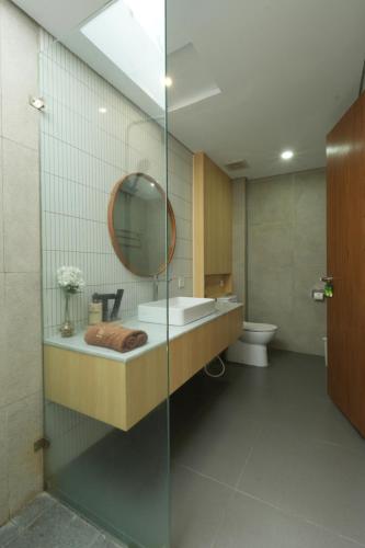 a bathroom with a sink and a mirror and a toilet at Lavana Villa by Raminten in Yogyakarta