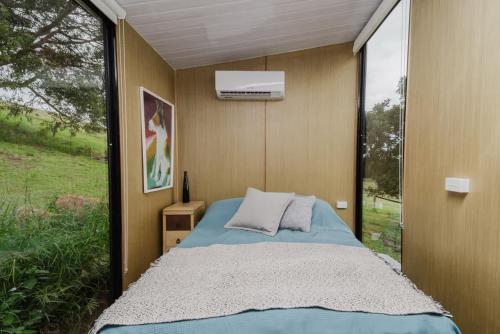 a bedroom with a bed and a large window at 8 Farm Macadamia Plantation 2 by Tiny Away in Cumbalum