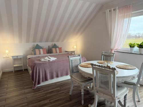 a bedroom with a bed and a table and chairs at Agritourism, family studio in Ładzin