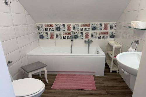 a bathroom with a tub and a toilet and a sink at Agritourism by the sea in Ładzin