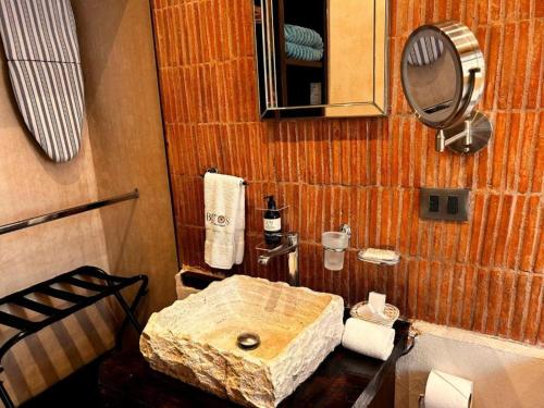a bathroom with a stone sink and a mirror at Hotel Bitos Boutique in San Miguel de Allende
