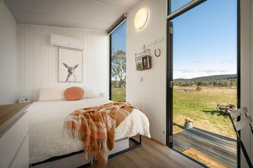 a bedroom with a bed and a large window at Clover at Lexington Park by Tiny Away in Tarlo