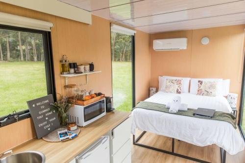 a small bedroom with a bed in a caravan at Gumnut by Tiny Away in Kangaroo Valley