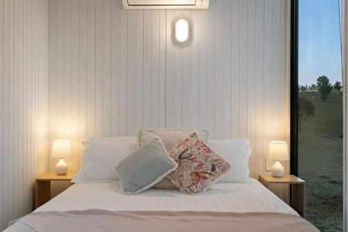 a bedroom with a bed with pillows and two lamps at The High Country Views Escape by Tiny Away in Table Top