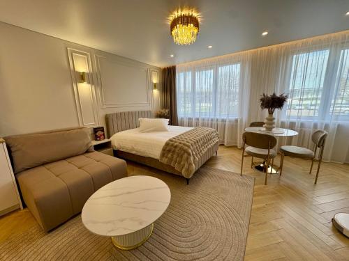 a bedroom with a bed and a couch and a table at Baltic Avenue in Klaipėda